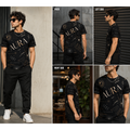 A man modeling a black short-sleeve t-shirt with a gold abstract graphic pattern and the word 'AURA' printed across the chest. The image is a multi-view collage showing the front, back, left side, right side, and close-up views of the shirt.